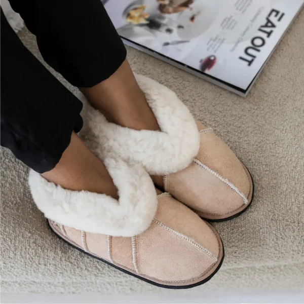 Lowveld Classic sheepskin slippers with soft wool cuff and practical design, worn for cosy indoor lounging.