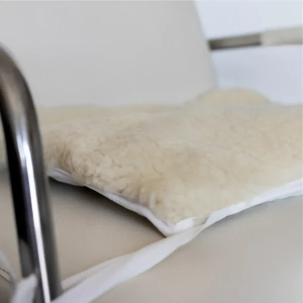 Sheepskin wheelchair cushion on a chrome and leather chair.