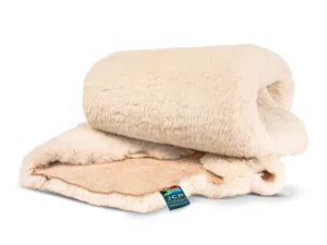 Folded baby sheepskin rug with visible wool pile and JCP Leathers product tag.