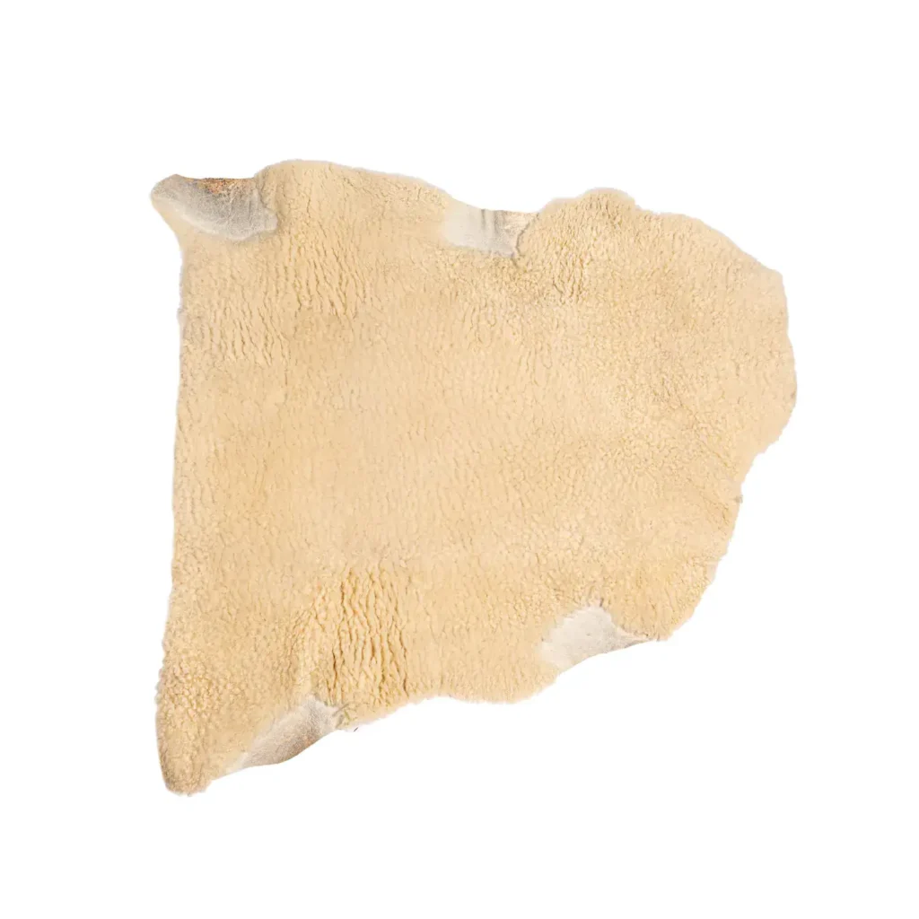 Natural medical sheepskin pad with dense wool fibres, shaped for pressure relief and comfort.