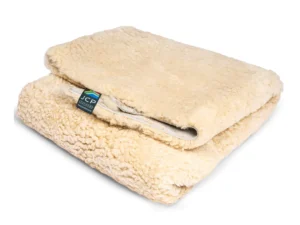 Folded medical-grade sheepskin showing plush wool texture and product tag.