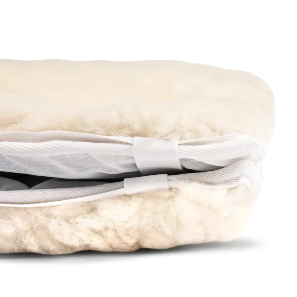 Angled view of sheepskin wheelchair cushion showing wool thickness and soft padding.
