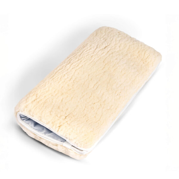 Folded sheepskin wheelchair cushion with a soft wool surface and white fabric base.